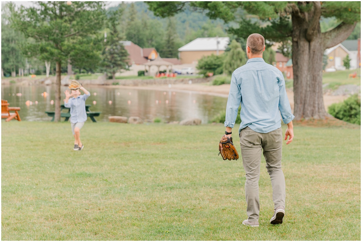 Dad with baseball glove with son catching ball in the background