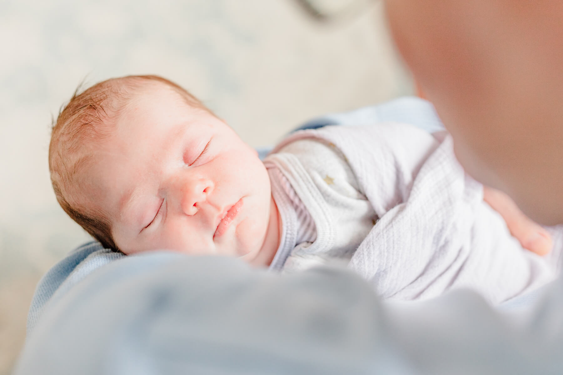 Newborn sleeping peacefully in dad's arms