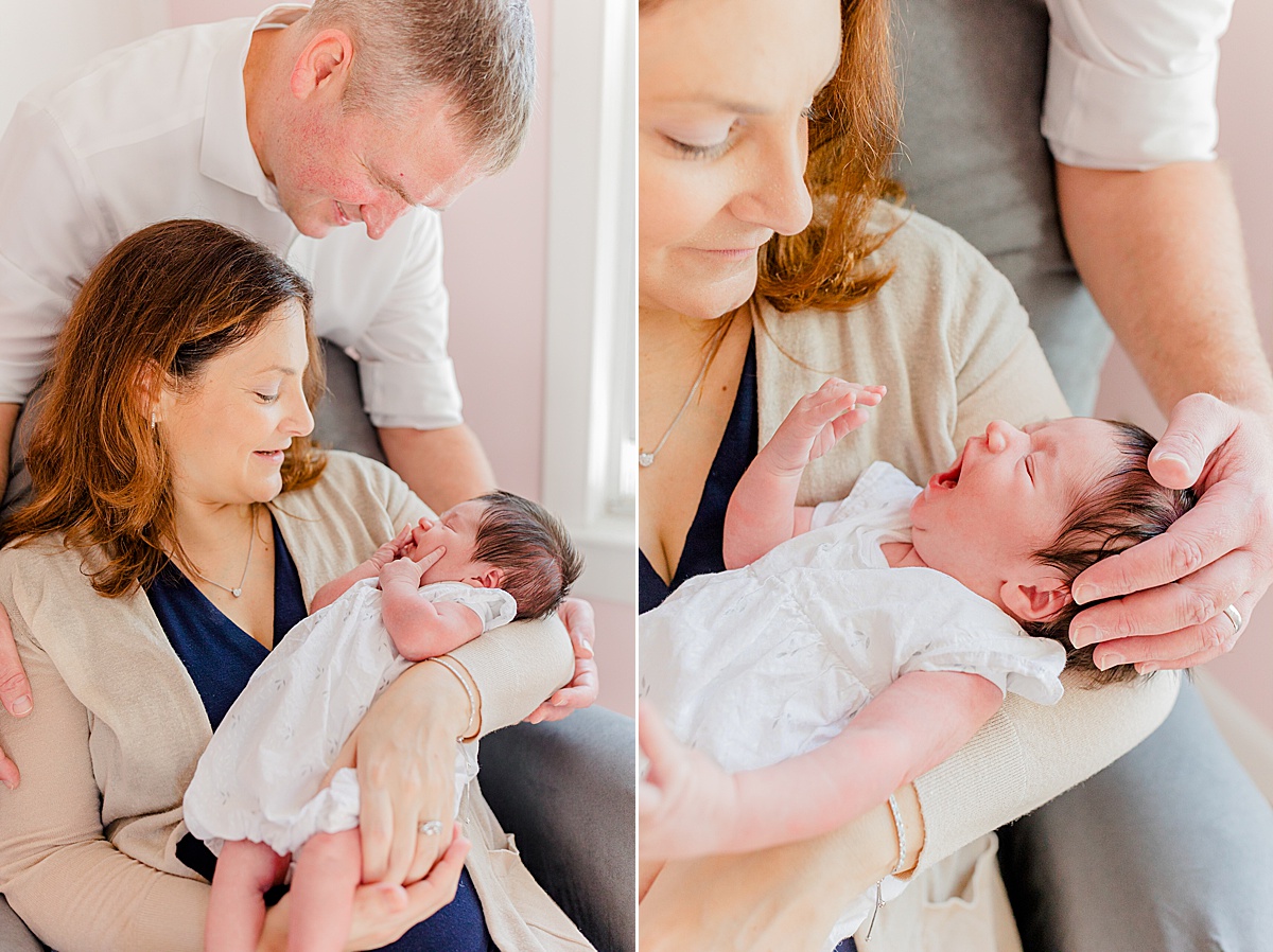 Example of lifestyle newborn images, 2 images side-by-side: Mother seated in chair holding and looking down at baby in her arms (both photos), in first photo, dad is visible standing over chair, leaning in and holding mom's elbow under the infant's head; in second image, dad's hand on the yawning infant's head is visible in a closeup