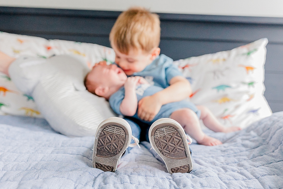 little boy kissing newborn sibling Boston Postpartum Doulas