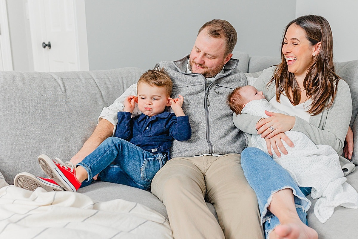 family with a newborn and toddler sitting on the couch Boston Postpartum Doulas