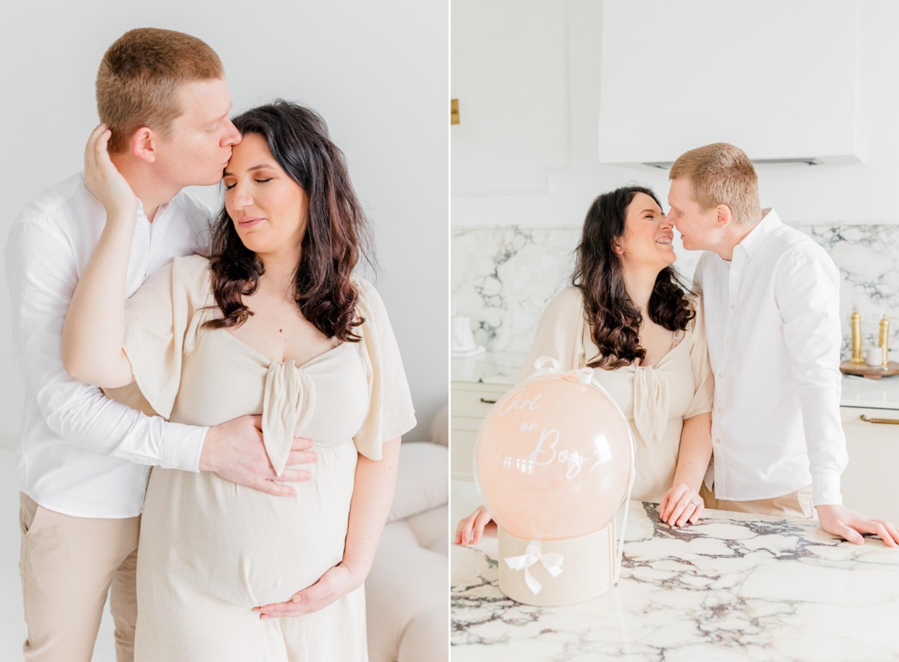 Expecting parents stand in a kitchen leaning in for a kiss with a balloon