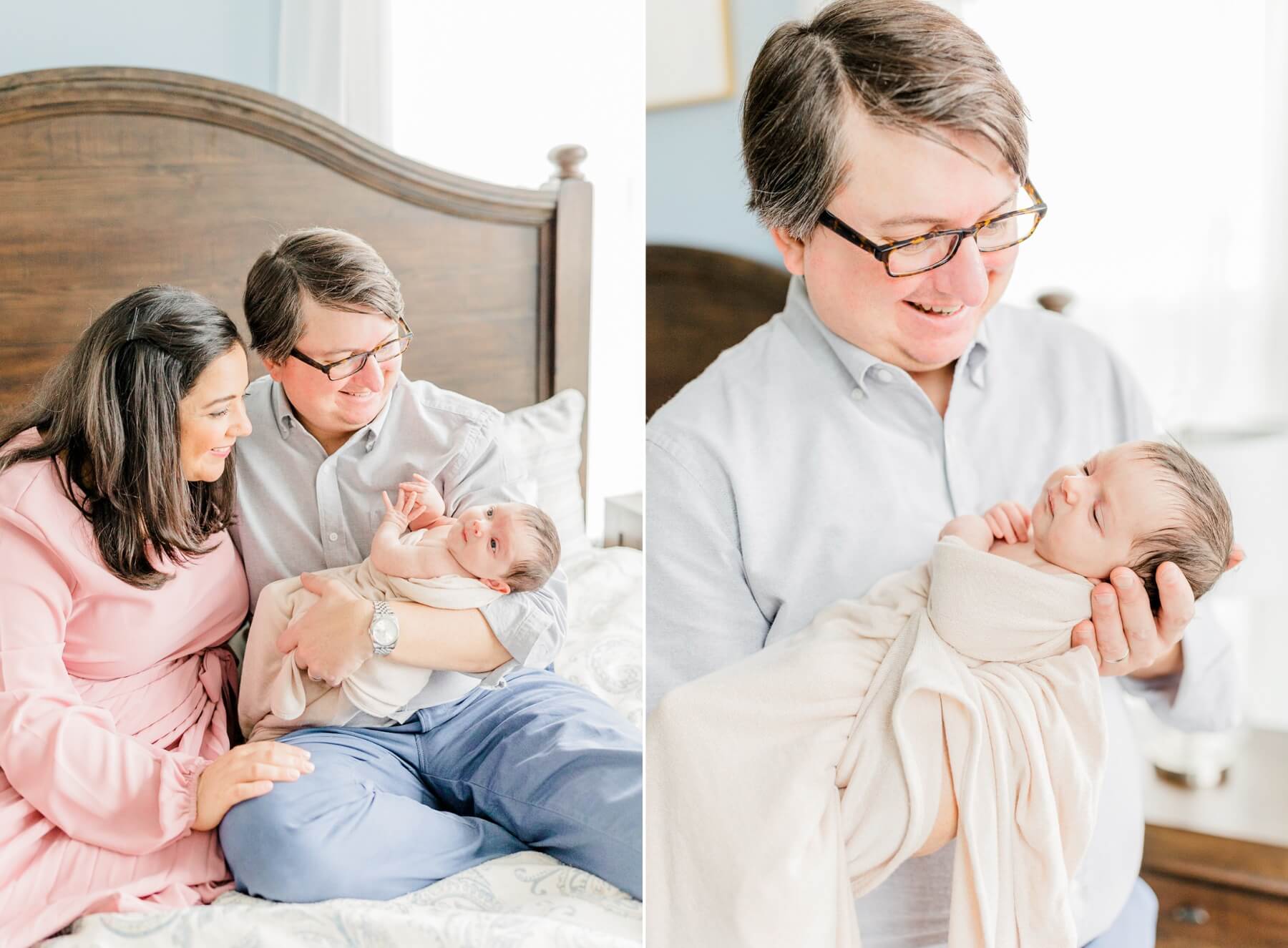 A happy father cradles his newborn baby while sitting on a bed with mom
